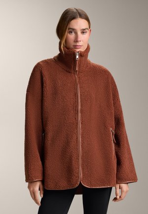 Braune Fleecejacke mit hohem Kragen, Reißverschluss vorne und Seitentaschen. Strukturierter Stoff und lockere Passform, mit kontrastfarbenem Besatz entlang der Kanten.