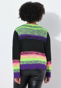 Pull en tricot noir avec de larges rayures horizontales en violet, vert et rose, doté d'un ourlet effiloché et de manches longues.