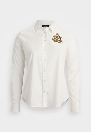 Camicia bianca a maniche lunghe in cotone, con un design di una corona ricamata in oro e le iniziali sul lato sinistro del petto, dal taglio classico.