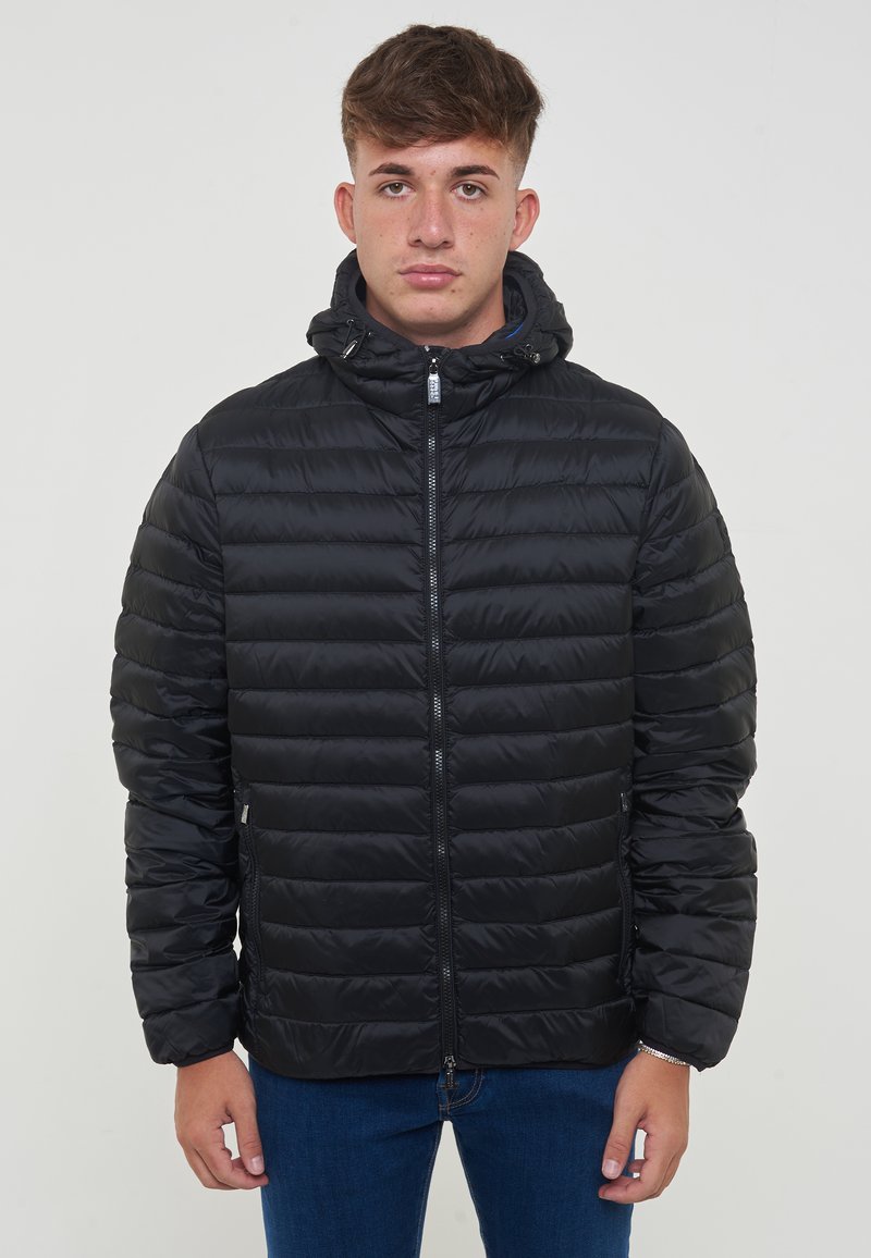 Giacca nera imbottita con cappuccio, caratterizzata da un design trapuntato orizzontale, chiusura frontale con zip e tasche laterali. Sembra leggera e liscia.