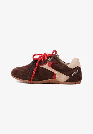Chaussure en daim marron avec des accents rouges et beiges. Comprend des lacets ronds rouges et noirs, une semelle en caoutchouc et des détails perforés sur la tige.