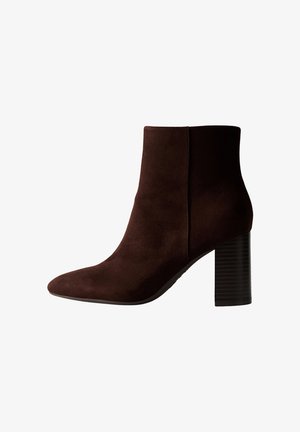 Stivale alla caviglia in suede marrone con punta appuntita e tacco a blocco rigato. Design elegante, texture liscia e silhouette aderente.