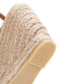 Wedge-sandaal met een bovenwerk van natuurlijk geweven jute, in een beige tint, en een textuur rubberen zool met een golvend patroon voor grip.