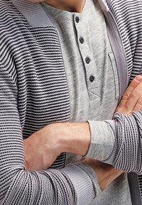 Gray striped zip-up cardigan over a gray henley shirt with a four-button placket. Visible texture in the knit pattern and fabric layers.