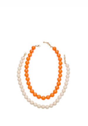 Dva náhrdelníky s korálkami so zlatými zapínaniami, jeden s veľkými lesklými oranžovými korálkami a druhý s veľkými lesklými bielymi korálkami, usporiadané na bielom pozadí.