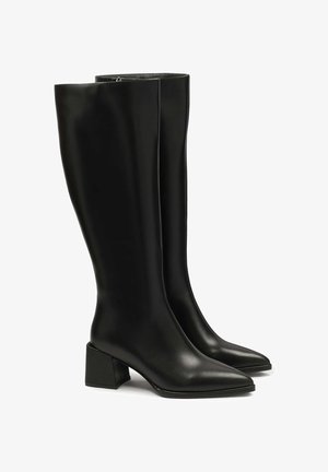 Crne kožne botine do koljena s šiljastim vrhom i debelim blok petom. Glatka tekstura, minimalno šivanje i jednostavan detalj zatvarača.