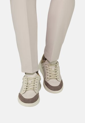 Beige Sneaker mit glattem Lederobermaterial und Wildlederakzenten, ausgestattet mit abgerundeter Spitze, Schnürverschluss und dicker weißer Gummisohle.