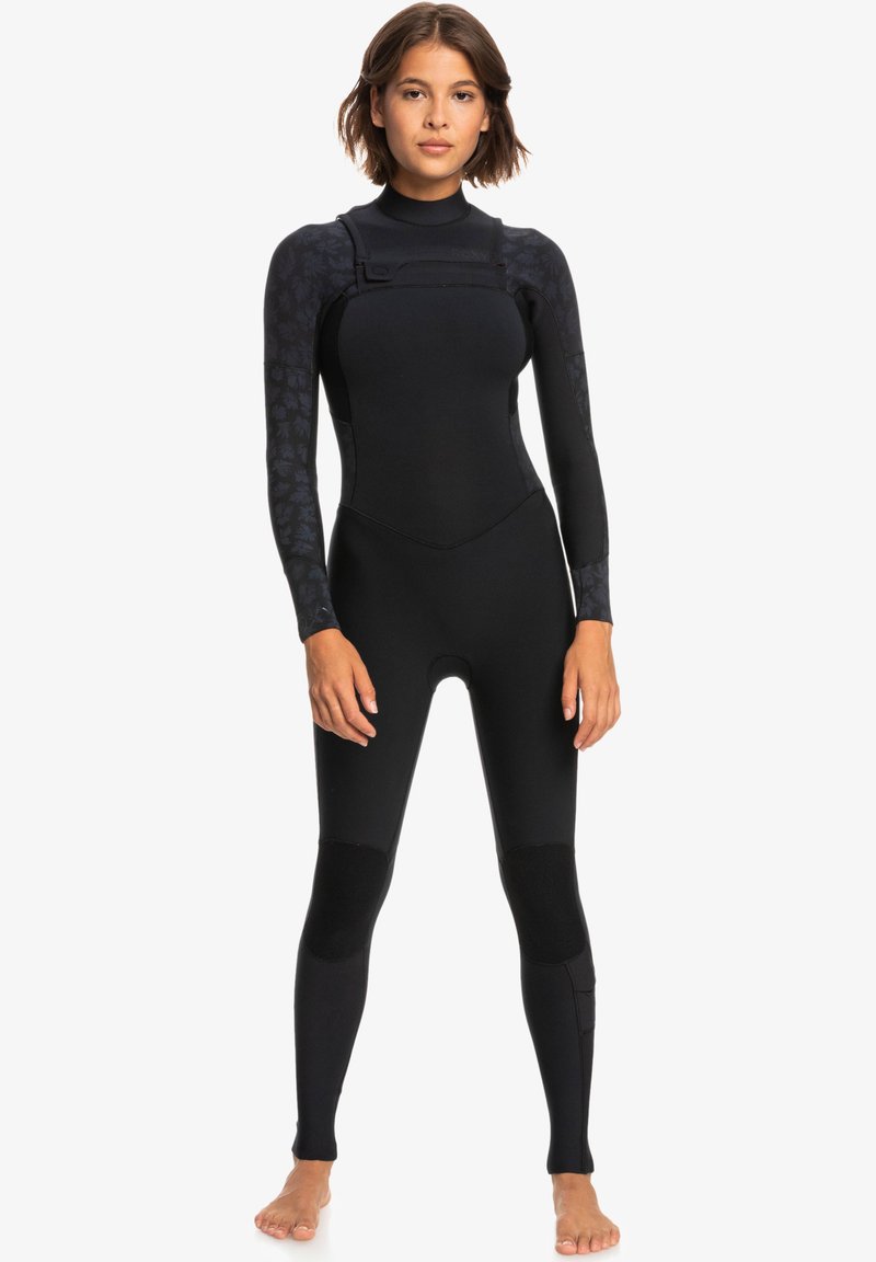 Black wetsuit featuring long sleeves, a high neck, and textured arm panels. Smooth, stretchy material with reinforced knee accents.