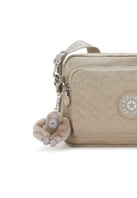 Beige nylon bag with a geometric pattern, rectangular shape, silver hardware, and a plush monkey charm attached. Features adjustable strap.