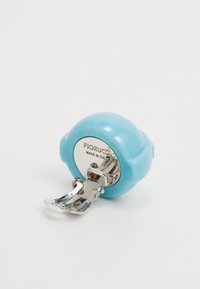 Turquoise round tape measure with a glossy finish, metal retracting mechanism, and engraved "Fiorucci Made in Italy" on the back.