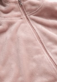 Fleece jack in zacht roze met een volledige rits. Kenmerkt zich door een gladde textuur en naaddetails, biedt warmte en comfort.
