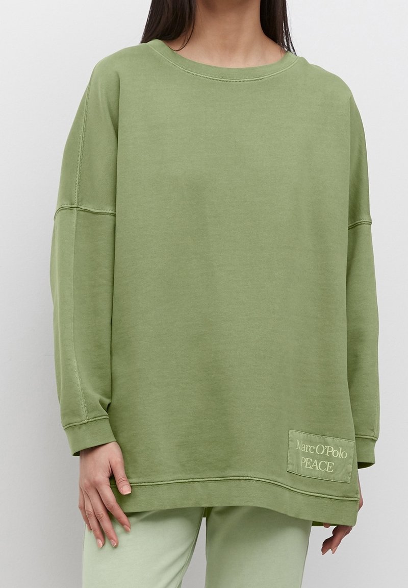 Felpa verde oversize realizzata in tessuto morbido, con scollo rotondo, spalle scese e tasca con ricamo "Marc O'Polo PEACE".