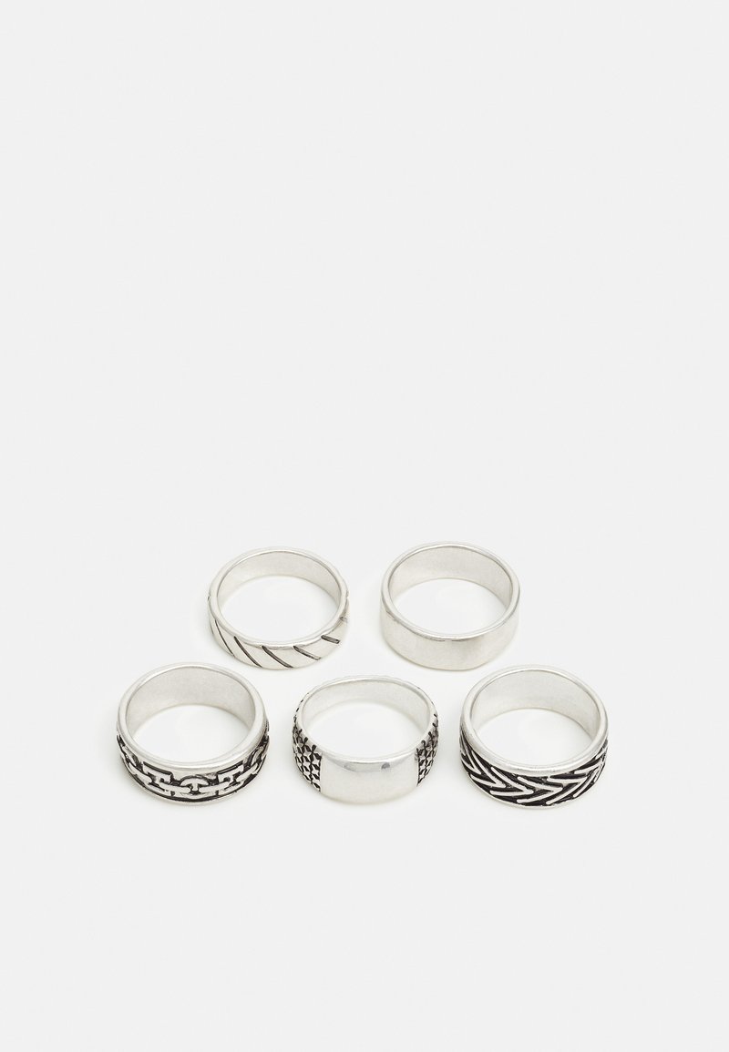 Ensemble de cinq bagues en argent présentant divers designs : tressée, en chaîne, lisse, texturée et avec des accents à motifs, de largeurs variées.