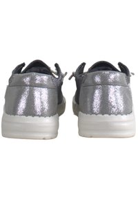 Sneakers argento con una finitura testurizzata, collo imbottito e suola bianca. Presentano cuciture sottili e un design flessibile per il massimo comfort.