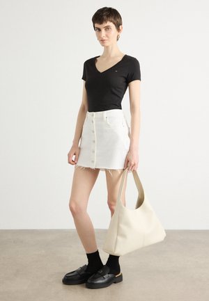 T-shirt nera a scollo a V, mini gonna di jeans bianca con bottoni frontali, borsa a spalla beige, mocassini neri, calzini alla caviglia, textures lisce, design casual.