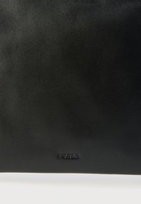 Sort lædertaske med en glat tekstur og præget logo. Rektangulær form, minimalistisk design uden ekstra accenter eller mønstre.