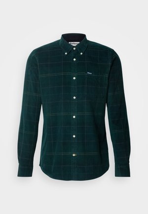 Green corduroy shirt with a button-down collar, featuring a plaid pattern and a chest pocket. White buttons and a branded label on the pocket.