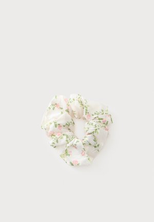 Hvid stof scrunchie med pink blomster og grønne blade mønster på en lys baggrund.