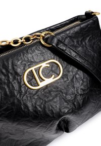 Bolso de cuero negro con textura arrugada, herrajes dorados, correa de cadena y un logotipo prominente cerca de la cremallera.