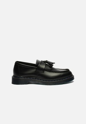 Μαύρο δερμάτινο loafer με φούντες, χοντρή σόλα και μπλε λεπτομέρεια ραφής, εμφανίζεται από το πλάι σε λευκό φόντο.