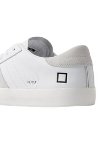 Sneakers bianchi in pelle con un accento in suede grigio sul tallone, lacci piatti e un logo quadrato nero sul lato. Suola in gomma.
