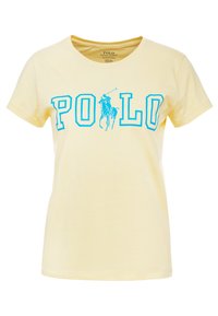 Gul bomullströja med fet blå text "POLO" och en logotyp av en polo-spelare. Klassisk passform med korta ärmar och rundad halsringning.