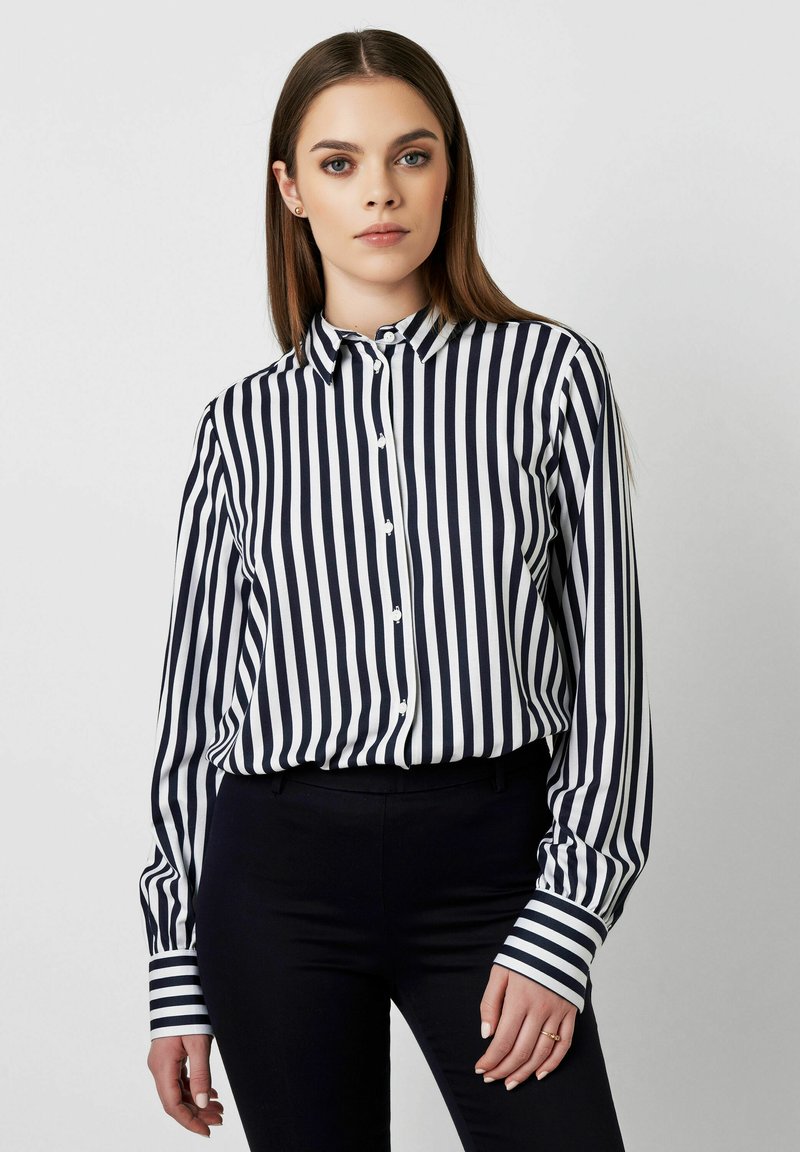 Navy and white striped button-up shirt with a collar, long sleeves, and distinct cuff detailing. Smooth fabric, tailored fit.