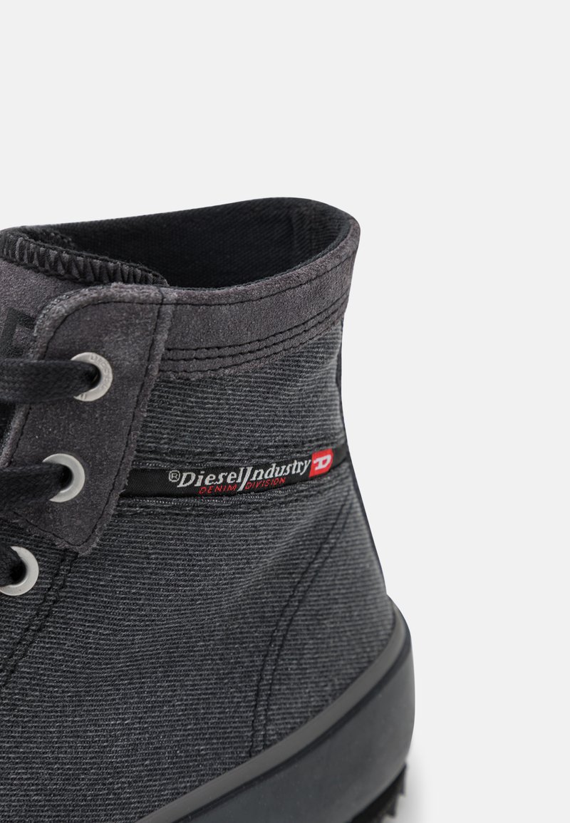 Zwarte denim enkelboot met grijze accenten, ronde neus en vetersluiting. Heeft een logo patch aan de zijkant en een gestructureerde stofafwerking.