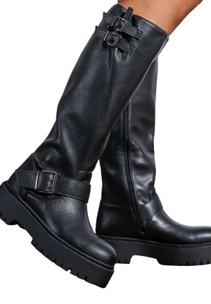 Bottes en cuir noir montantes avec finition texturée, dotées de deux accents à boucle et d'une semelle en caoutchouc épaisse pour une meilleure adhérence.