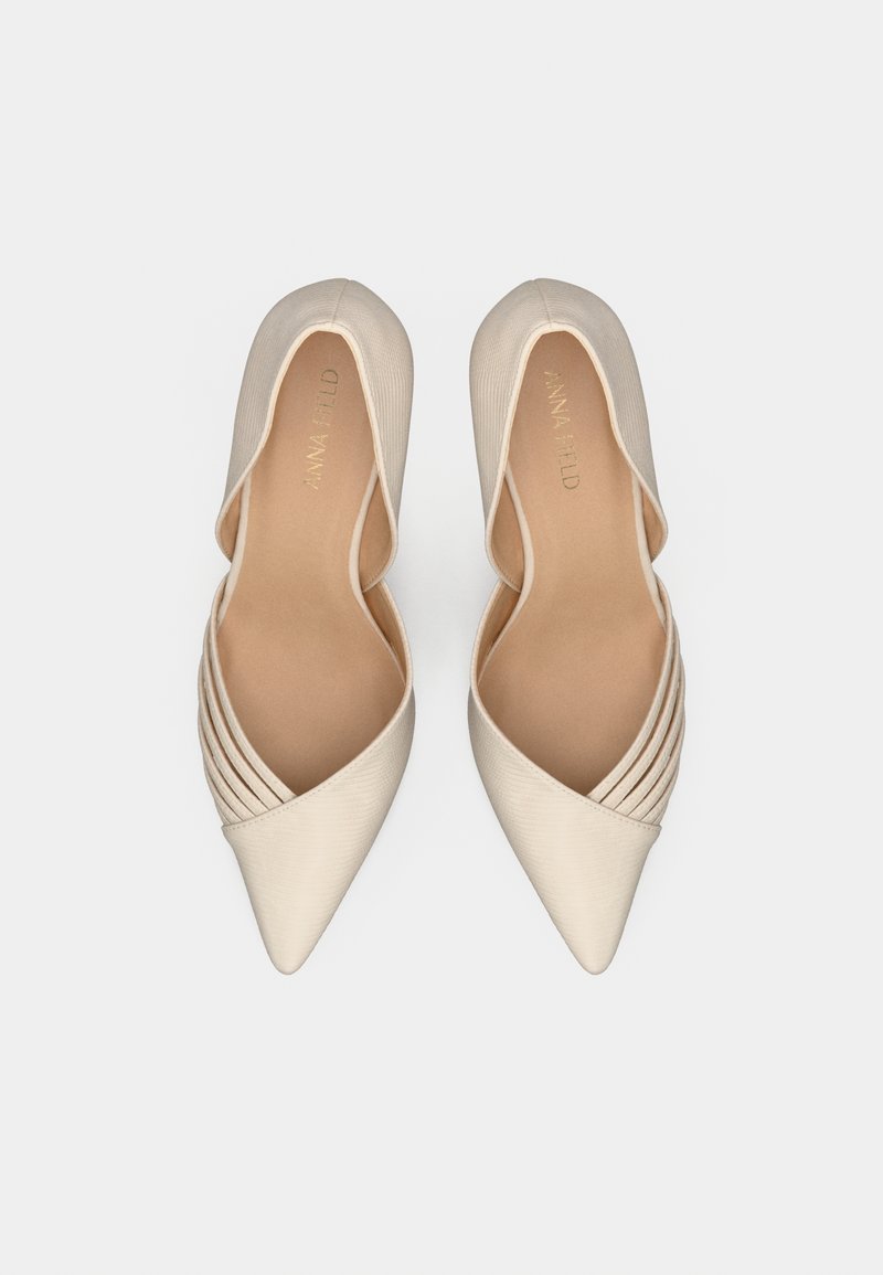 Zapatos de punta beige con un acabado satinado suave, que cuentan con acentos plisados en el lateral y un forro interno suave.