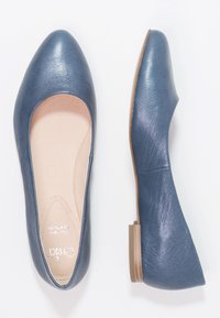 Pár modrých kožených balerín s kulatou špičkou a nízkými čtvercovými podpatky, zobrazených z horního a bočního pohledu na bílém pozadí.