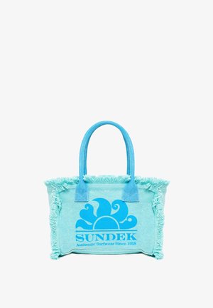 Een turkooizen stoffen draagtas met franjes, voorzien van een blauw golflogo en twee stevige handvatten. Compact en casual ontwerp.