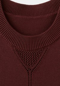 Gros plan sur le col d'un pull en maille bordeaux avec un encolure côtelée et un détail triangulaire en maille texturée en dessous.