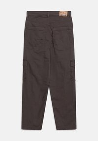 Des pantalons cargo en tissu gris foncé présentent une coupe décontractée, des poches arrière et des accents de poches latérales pour plus de praticité. Coutures durables tout au long.