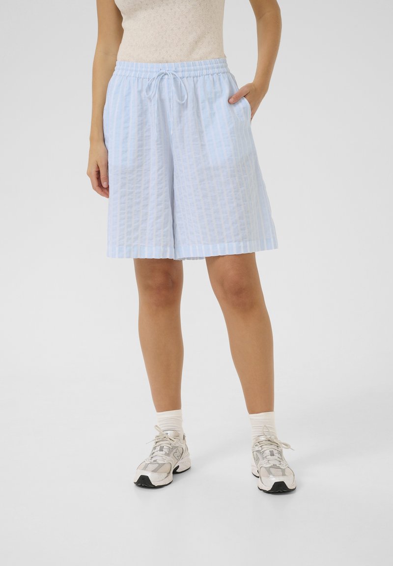 Ljusblå, knälånga shorts tillverkade av en texturerad tyg med vertikala ränder, utrustade med ett elastiskt midjeband och sidofickor.
