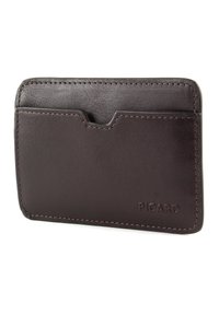 Brown leather cardholder with a smooth texture, rounded edges, and a front slot. Features visible stitching and a logo on the bottom right.