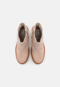 Botas de tobillo de ante beige con parte superior texturizada, paneles elásticos en los laterales y suelas de goma. El forro interior presenta una marca en gris.