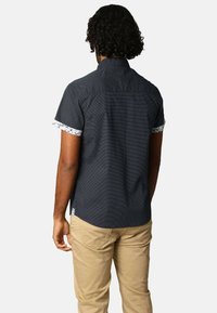 Korte mouwen shirt in marineblauw met een gestructureerd patroon, voorzien van een bloemenprint op de manchetten en een standaard kraag.