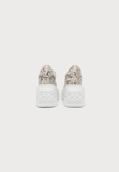 Paire de baskets compensées blanches avec un motif peau de serpent texturé sur la tige, vues de dos sur un fond uni.