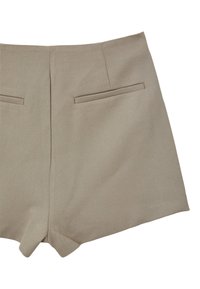 Pantaloni corti beige su misura realizzati in un tessuto testurizzato. Le caratteristiche includono due tasche posteriori e un orlo pulito con una leggera fessura nella parte inferiore.