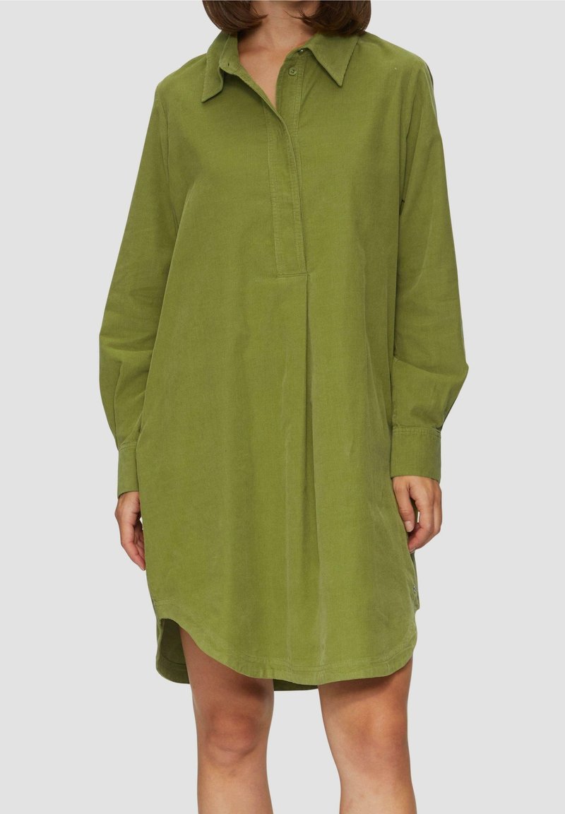 Vestido de camisa verde de manga larga hecho de una tela suave. Presenta un collar, una tapeta de botones y un ajuste relajado con un dobladillo ligeramente curvado.