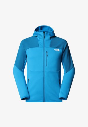 Niebieska polarowa kurtka z zamkiem z przodu, kapturem i dwiema bocznymi kieszeniami. Charakteryzuje się kontrastowym wzornictwem na ramionach oraz logo na klatce piersiowej.