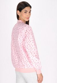 Roze bomberjack met een klein rood stippenpatroon, ribgebreide manchetten en zoom, een gladde textuur en een relaxed pasvorm.