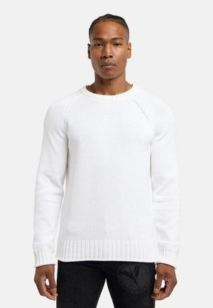 Hvid strikket sweater med ribstrikkede manchetter og kant. Har en rund halsudskæring og diskret branding på skulderen. Glat tekstur.