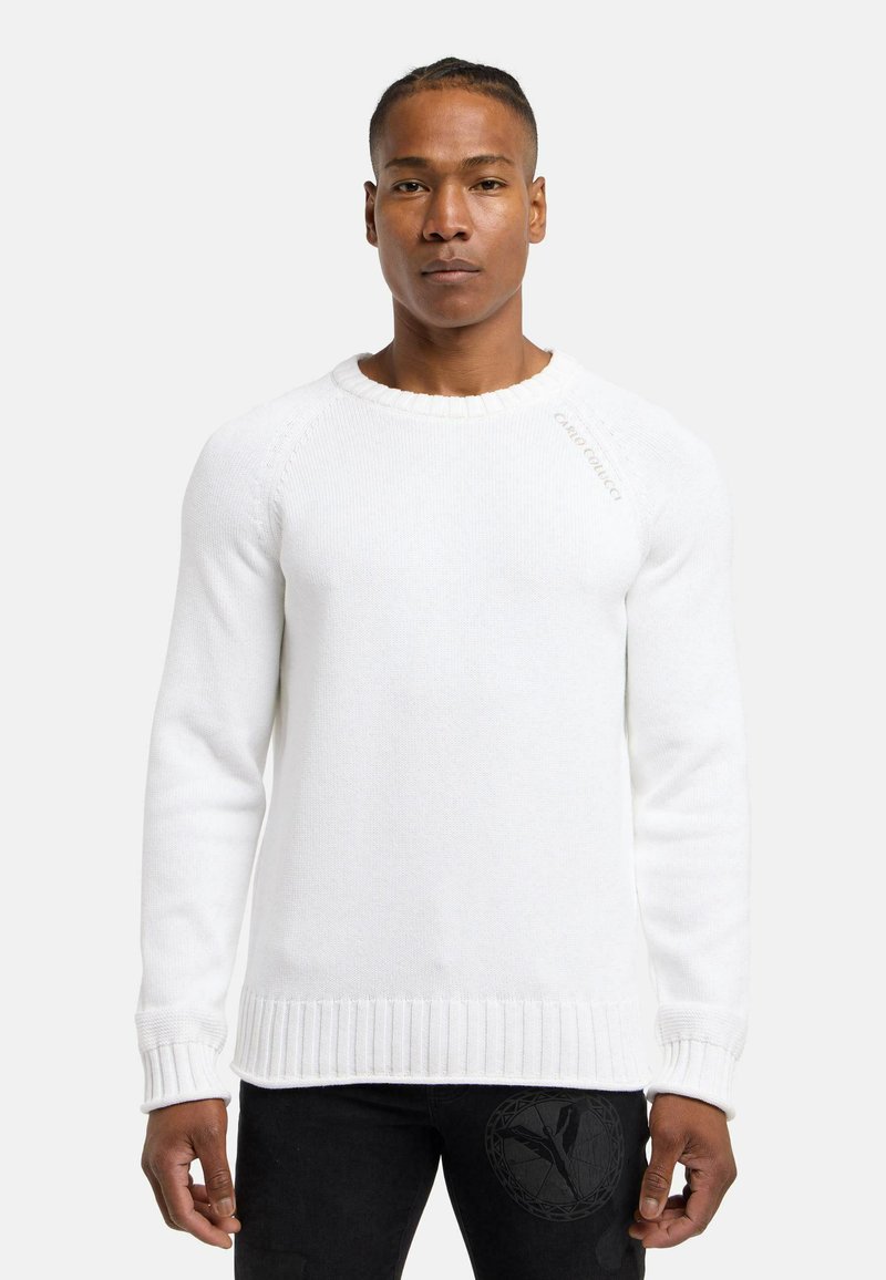 Hvid strikket sweater med ribstrikkede manchetter og kant. Har en rund halsudskæring og diskret branding på skulderen. Glat tekstur.