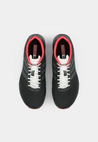 Black athletic shoes with a smooth texture, red accents, white laces, and three black stripes on each side. Rounded toe and cushioned sole.