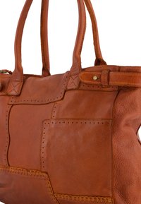 Sac à main en cuir marron avec un design en patchwork comportant des sections texturées, des coutures contrastantes et deux poignées en cuir.