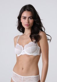 Bra bianco in pizzo con design a sottoseno, bordi a scallop e spalline regolabili, abbinato a un perizoma in pizzo coordinato.