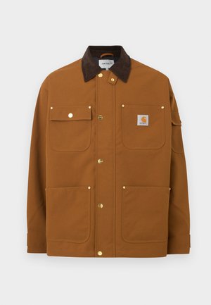 Brun arbejdsjakke med mørkebrun fløjlskrave, fire frontlommer, guldknapper med tryk og en Carhartt-logo lap på den øverste højre lomme.