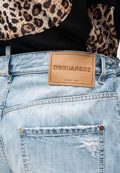 Ανοιχτό μπλε τζιν με φθαρμένο εφέ, καφέ δερμάτινη ετικέτα DSQUARED2 και ύφασμα με λεοπάρ μοτίβο που είναι στερεωμένο στη μέση.